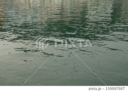 Water textures with light and ripples. Moving water in the harbour give beautiful shimmery textures and surfaces for backgrounds with space for copy 130097087
