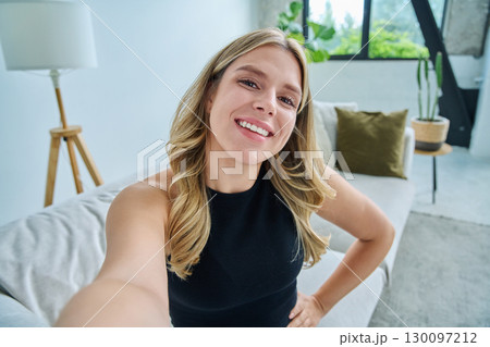Selfie portrait happy beautiful young woman in home interior Selfie portrait happy beautiful young woman in home interior 130097212