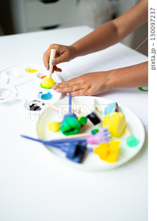 Child creating colorful artwork with paints and clay Child creating colorful artwork with paints and clay 130097237