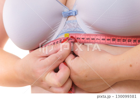Woman plus size measuring her chest under breasts Woman plus size measuring her chest under breasts 130099381
