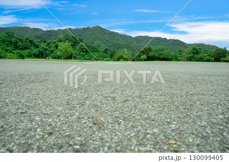 Empty helicopter landing pad with asphalt with green mountain forest background providing emergency medical transport access to remote wilderness areas. Helipad platform at dam infrastructure site. 130099405