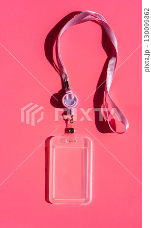 Pink lanyard with smiley badge holder on bright background 130099862