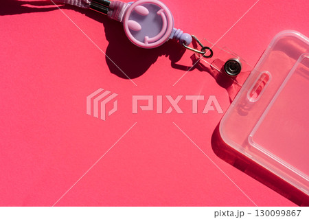 Smiley face badge holder with lanyard on pink surface 130099867