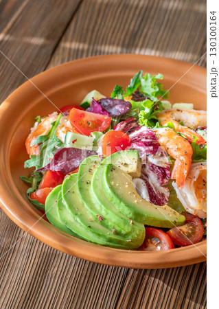 Fresh prawn avocado salad cherry tomatoes wooden table citrus dressing Fresh prawn avocado salad cherry tomatoes wooden table citrus dressing 130100164