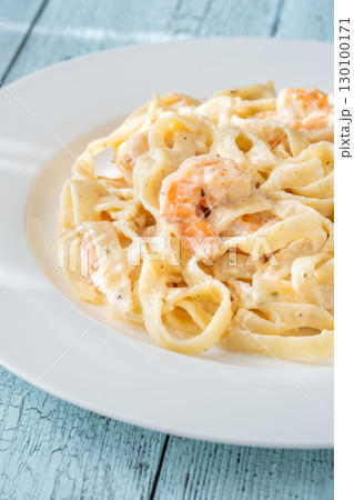 Creamy fettuccine shrimp pasta white plate savory sauce gourmet flavor Creamy fettuccine shrimp pasta white plate savory sauce gourmet flavor 130100171
