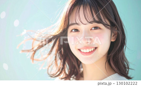 柔らかな風に髪が揺れるスタジオで微笑む若い女性 柔らかな風に髪が揺れるスタジオで微笑む若い女性 130102222