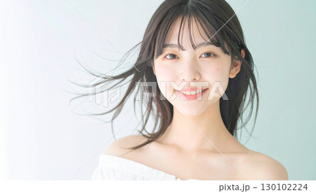 柔らかな風に髪が揺れるスタジオで微笑む若い女性 柔らかな風に髪が揺れるスタジオで微笑む若い女性 130102224