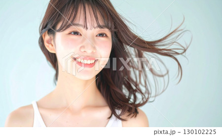 柔らかな風に髪が揺れるスタジオで微笑む若い女性 柔らかな風に髪が揺れるスタジオで微笑む若い女性 130102225