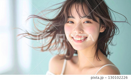 柔らかな風に髪が揺れるスタジオで微笑む若い女性 柔らかな風に髪が揺れるスタジオで微笑む若い女性 130102226