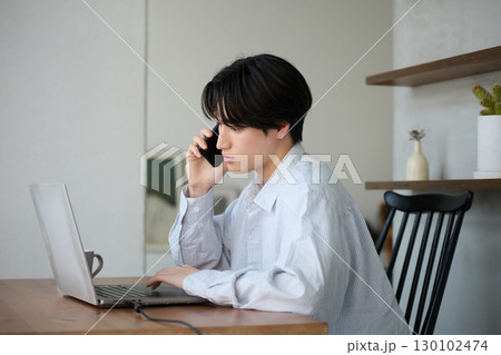 自宅で仕事をしているアジアの若い男性 自宅で仕事をしているアジアの若い男性 130102474