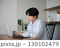 自宅で仕事をしているアジアの若い男性 130102479