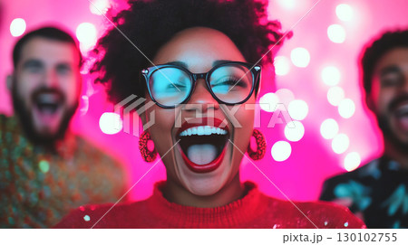 group of friends celebrating joyfully with bright lights in background. woman in front is smiling widely, showcasing her excitement and happiness 130102755