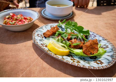 Traditional Turkish Cig Kofte Served with Fresh Herbs and Lemon 130102997