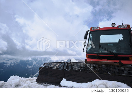 Red Snow Groomer on Snowy Mountain Ridge under Cloudy Sky 130103026