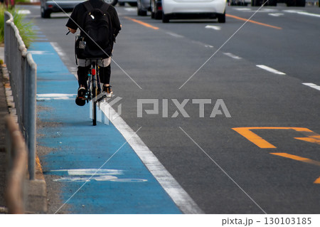 広い通りの自転車ナビラインを走る自転車 130103185