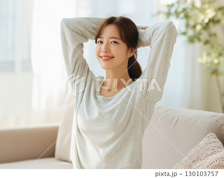 自然光の中でストレッチで一日をスタートする幸せな朝のワンシーン	 130103757