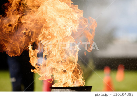 Blazing Flames. Firefighters practice controlling an outdoor fire with extinguishers 130104385