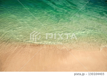 Tranquil Shoreline. Clear turquoise water gently laps against a sandy beach. Tranquil Shoreline. Clear turquoise water gently laps against a sandy beach. 130104403