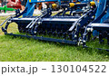 Agricultural machinery close-up with metal components and red frame. 130104522