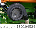 Close-up of a black industrial fan on green and orange machinery. 130104524