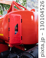 Close-up of a red fire extinguisher container on an industrial vehicle. 130104526