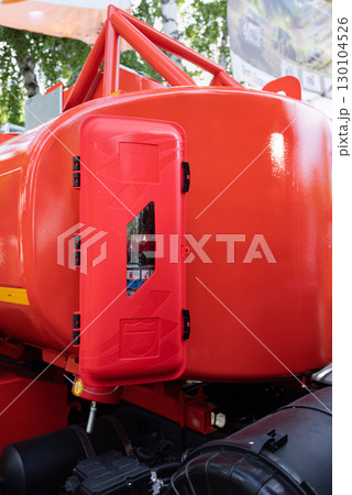 Close-up of a red fire extinguisher container on an industrial vehicle. Close-up of a red fire extinguisher container on an industrial vehicle. 130104526