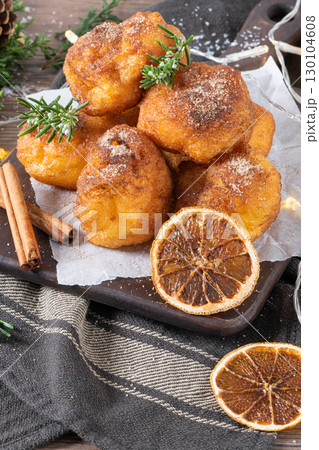 Traditional portuguese Christmas sweets Sonhos with sugar and cinnamon on kitchen countertop. 130104608