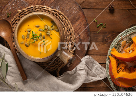 Tasty pumpkin cream soup with organic herbs and pumpkin seeds in vintage ceramic bowl Tasty pumpkin cream soup with organic herbs and pumpkin seeds in vintage ceramic bowl 130104626