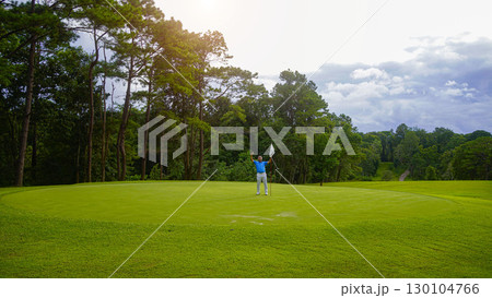 Golfers are putting golf in the evening golf course golf backglound. Golfer hitting golf ball. 130104766