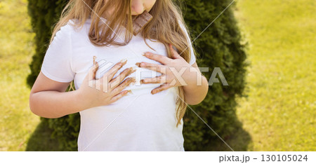Girl child staining her white t-shirt with stain while enjoying a delicious chocolate bar in garden Girl child staining her white t-shirt with stain while enjoying a delicious chocolate bar in garden 130105024