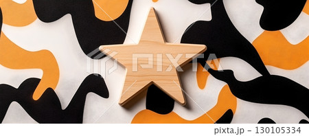 A wooden star shaped object resting on a minimalist abstract geometric pattern background in contrasting black white and orange colors 130105334