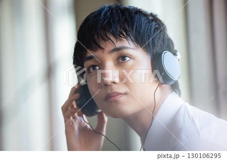 音楽を聴く若い男性 130106295