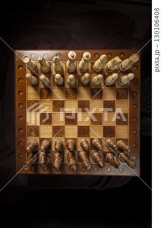 Chess pieces of wood on a beautiful chessboard. A puzzle game with tricky combinations that requires planning and thinking. Chess pieces of wood on a beautiful chessboard. A puzzle game with tricky combinations that requires planning and thinking. 130106408
