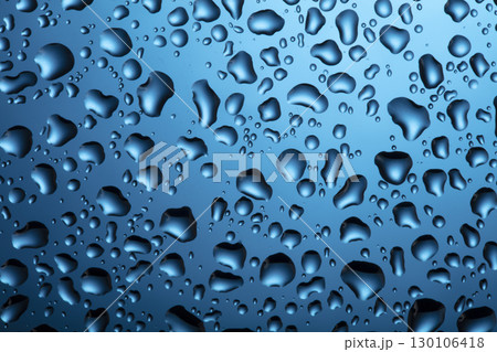 Water drops on glass on a blue background. Water drops on glass on a blue background. 130106418