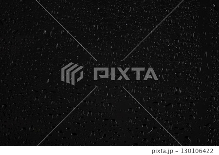 Water drops on glass on a black background. Water drops on glass on a black background. 130106422