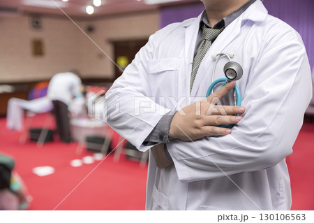Doctor in gown uniform with stethoscope standing and fold his arms over the chest in blood donor room 130106563