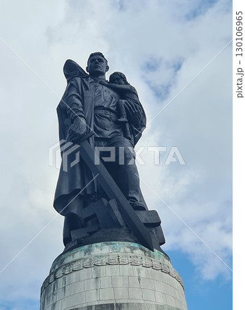 Berlin, Germany - August 1, 2025: Soviet War Memorial, Treptower Park, bronze statue of a Soviet soldier with a sword holding a German child, standing over a broken swastika 130106965