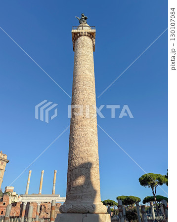 Trajan's Column that commemorates Roman emperor victory in the Dacian Wars, located in Trajan's Forum with ancient ruins and classical architecture surrounding it in Rome, Italy 130107084