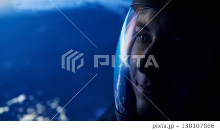 Close up view of woman in glassed space helmet against blue background 130107866