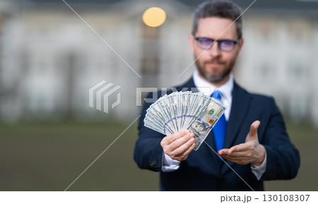 Businessman broker count money. Property concept. Successful realtor in suit with money dollar. House owner hold money outdoor. Realtor offering new home. Broker make offer, selective focus Businessman broker count money. Property concept. Successful realtor in suit with money dollar. House owner hold money outdoor. Realtor offering new home. Broker make offer, selective focus 130108307