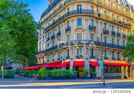 Paris city with street cafe restaurant on boulevard, traditional Parisian architecture apartment building with typical facade, balconies and windows iron fences in Le Marais historic district Paris city with street cafe restaurant on boulevard, traditional Parisian architecture apartment building with typical facade, balconies and windows iron fences in Le Marais historic district 130108308