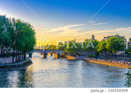 Paris cityscape of historic city center with Pont Marie bridge across Seine river, Saint-Louis island, Voie Georges Pompidou expressway promenade embankment on sunset, Paris evening view, France 130108309