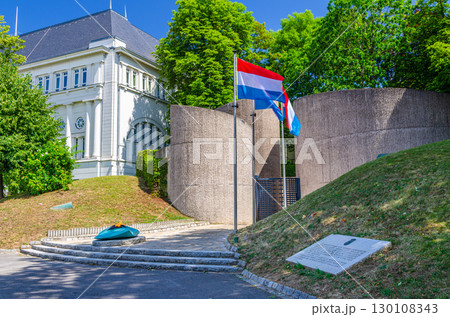 National Monument of Solidarity at Cannon Hill Kanounenhiwwel, Luxembourg flags on poles and green trees in Luxembourg city historical centre 130108343