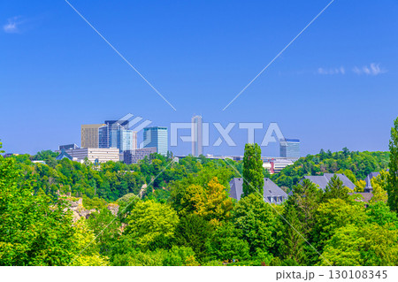 Luxembourg City aerial panoramic view of Kirchberg central business district with skyscraper buildings and Three Acorns Park with green trees, Luxembourg cityscape skyline horizon with blue sky 130108345