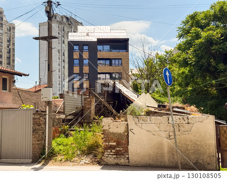 Abandoned building with collapsed roof and crumbling walls in an urban neighborhood. Urban decay, transformation and changing cityscape. Abandoned building with collapsed roof and crumbling walls in an urban neighborhood. Urban decay, transformation and changing cityscape. 130108505