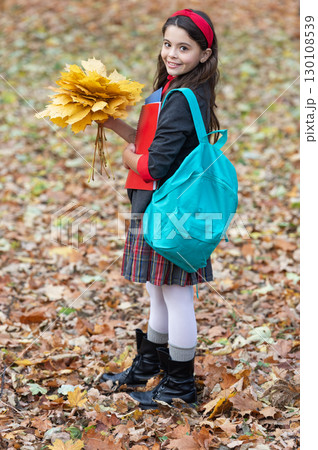 Stylish teen girl at school break. Back to school. Autumn fall leaves. Knowledge and education. Knowledge day. School education. Autumn girl in uniform hold fall leaves outdoor. Autumn sale Stylish teen girl at school break. Back to school. Autumn fall leaves. Knowledge and education. Knowledge day. School education. Autumn girl in uniform hold fall leaves outdoor. Autumn sale 130108539