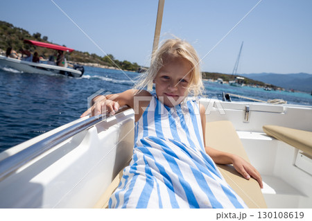 Blond child relaxing on a boat during summer vacation, sailing in the beautiful waters of Greece Blond child relaxing on a boat during summer vacation, sailing in the beautiful waters of Greece 130108619