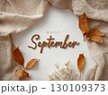 The image features the words 'Hello September' on a textured beige background with shadows and leaves around the edges. 130109373
