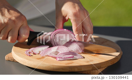 chef cuts fresh red onion on cutting board chef cuts fresh red onion on cutting board 130109441