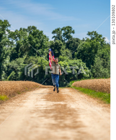 Independence day. Man in field. Man with American flag in crop field. Independence day of America. 4th of July. American labor day. American flag and man farmer. Flag of USA. Free and happy Independence day. Man in field. Man with American flag in crop field. Independence day of America. 4th of July. American labor day. American flag and man farmer. Flag of USA. Free and happy 130109802